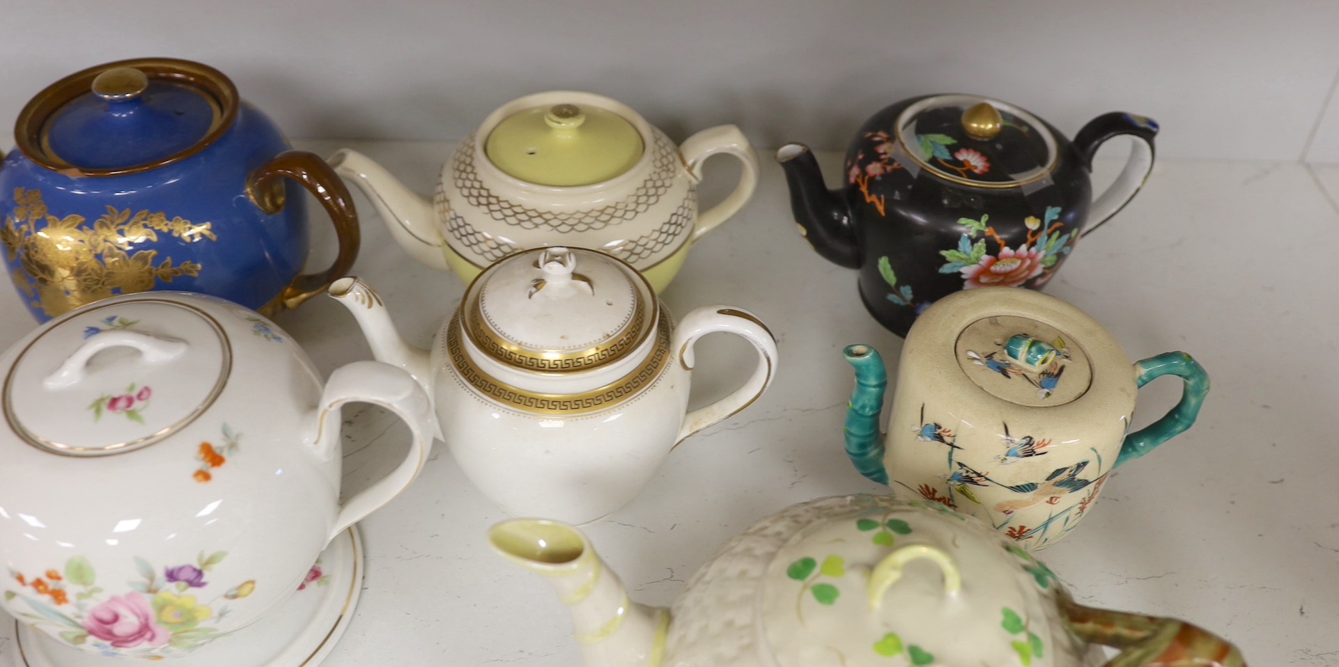 A quantity of various teapots including Belleek, Japanese Satsuma etc.